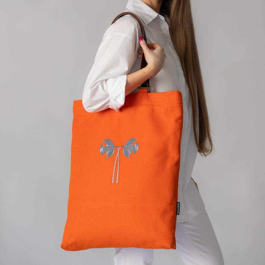 Oversized orange cotton canvas bag with daffodils and leather handles