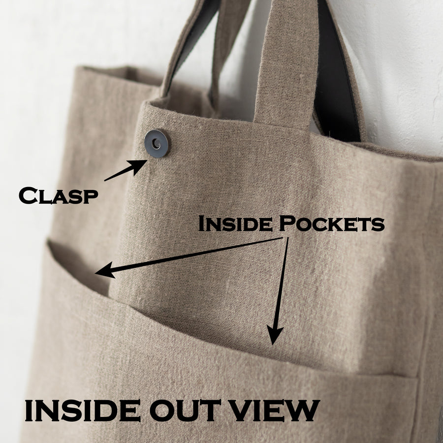 Inside out view of a handmade linen back - pockets and a clasp with leather handles