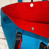 Blue cotton canvas bag with red lining and metal clasp to secure