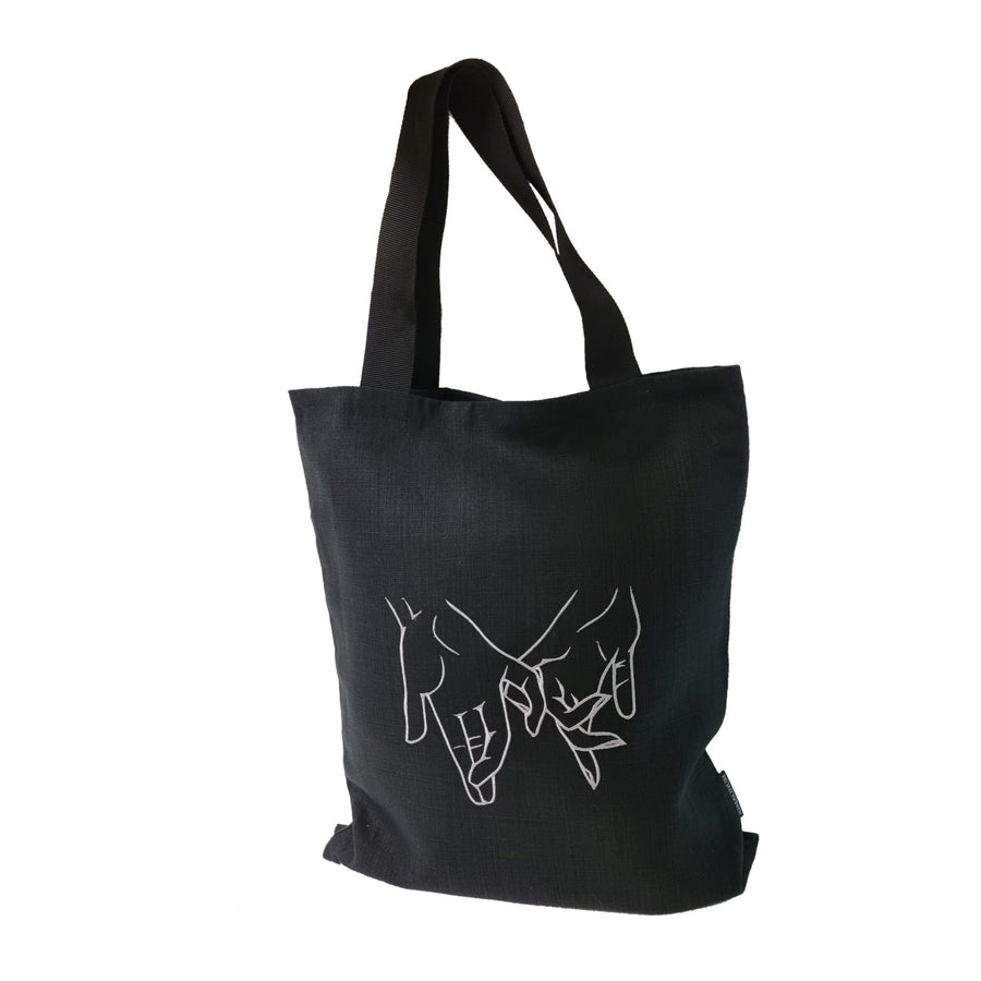 View of a black tote shoulder bag with male and female hands embroidery