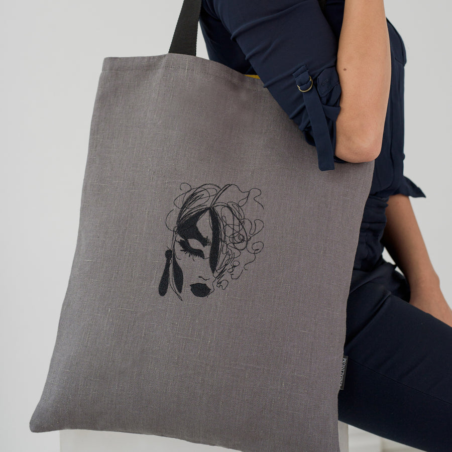 Woman face embroidered linen tote bag